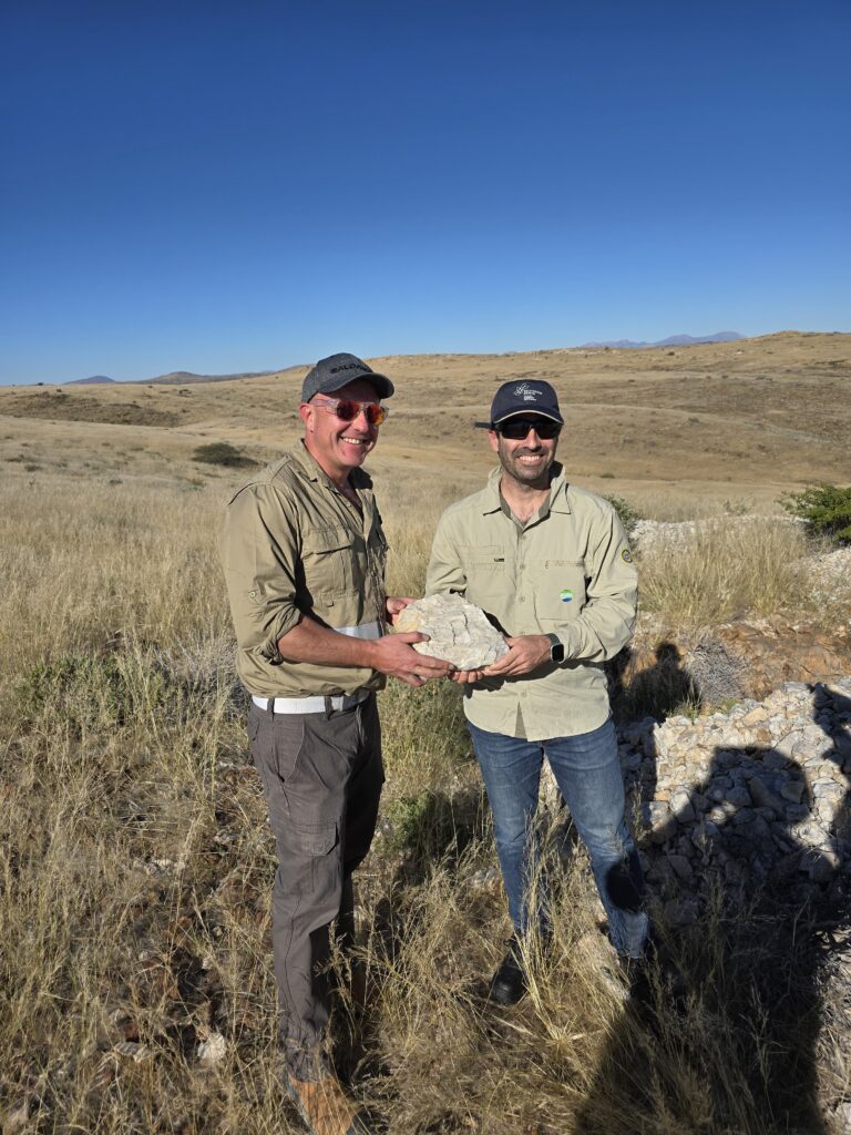 Andrada and SQM International Lithium CEOs holding a spodumene crystal at Lithium Ridge, Namibia